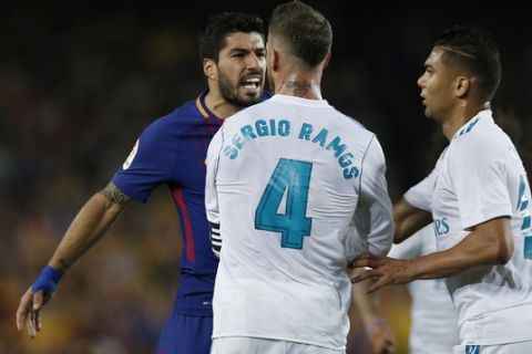 Barcelona's Luis Suarez, left, confronts Real Madrid's Sergio Ramos during a Spanish La Liga soccer match between Barcelona and Real Madrid, dubbed 'el clasico', at the Camp Nou stadium in Barcelona, Spain, Sunday, May 6, 2018. (AP Photo/Manu Fernandez)