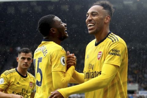 Arsenal's Pierre-Emerick Aubameyang, right, celebrates scoring his side's first goal of the game with teammate Ainsley Maitland-Niles  during the English Premier League soccer match between Newcastle United and Arsenal, at St James' Park, in Newcastle, England, Sunday, Aug. 11, 2019. (Owen Humphreys/PA via AP)