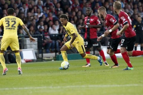 PSG's Neymar, center, controls the ball while his teammate Dani Alves looks on during their French League One soccer match between Guingamp and PSG at the Roudourou stadium in Guingamp, western France, Sunday, Aug. 13, 2017. Neymar makes his long-awaited debut with Paris Saint-Germain on Sunday in the small Brittany town of Guingamp. (AP Photo/Kamil Zihnioglu)