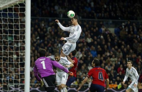 Real Madrid's Cristiano Ronaldo from Portugal jumps in between players as he tries to score during a Spanish Copa del Rey soccer match between Real Madrid and Osasuna at the Santiago Bernabeu stadium in Madrid, Spain, Thursday, Jan. 9, 2014. (AP Photo/Andres Kudacki)