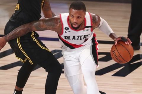 Portland Trail Blazers guard Damian Lillard (0) drives to the basket against Los Angeles Lakers guard Kentavious Caldwell-Pope (1) in the first half of Game 4 of an NBA basketball first-round playoff series, Monday, Aug. 24, 2020, in Lake Buena Vista, Fla. (Kim Klement/Pool Photo via AP)
