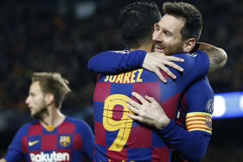 Barcelona's Luis Suarez is congratulated by Lionel Messi, right, after scoring the opening goal during a Champions League soccer match Group F between Barcelona and Dortmund at the Camp Nou stadium in Barcelona, Spain, Wednesday, Nov. 27, 2019. (AP Photo/Joan Monfort)