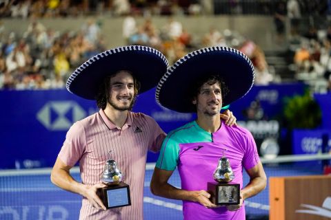 Greece's Stefanos Tsitsipas, left, and Spain's Feliciano Lopez pose for photos after winning the doubles final match against El Salvador's Marcelo Arevalo and Netherland's Jean-Julien Rojer at the Mexican Open tennis tournament in Acapulco, Mexico, Saturday, Feb. 26, 2022. (AP Photo/Eduardo Verdugo)