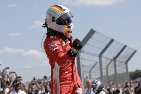 Ferrari driver Sebastian Vettel of Germany jumps from the car in celebration after winning the British Formula One Grand Prix at the Silverstone racetrack, Silverstone, England, Sunday, July 8, 2018. (AP Photo/Luca Bruno)