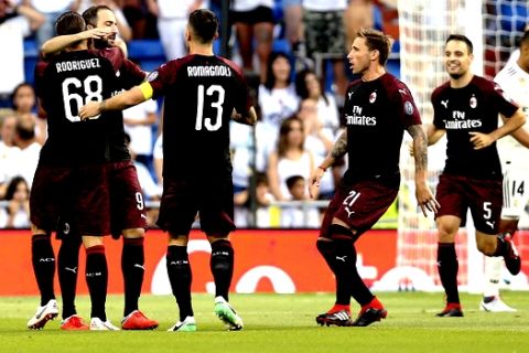 AC Milan's Argentine Gonzalo Higuain, second right, celebrates with teammates after scoring their side's first goal against Real Madrid during the Santiago Bernabeu trophy soccer match between Real Madrid and AC Milan at the Santiago Bernabeu stadium, in Madrid, Saturday, Aug. 11, 2018. (AP Photo/Andrea Comas)