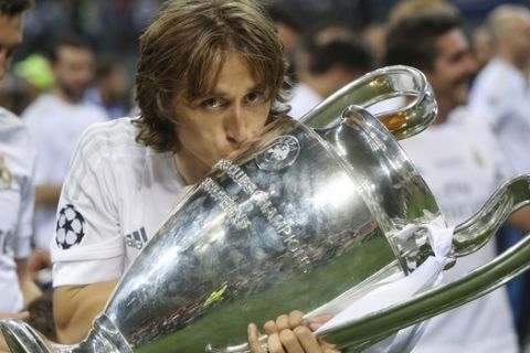 Real Madrid's Luka Modric kisses the trophy after the Champions League final soccer match between Real Madrid and Atletico Madrid at the San Siro stadium in Milan, Italy, Saturday, May 28, 2016. Real Madrid won 5-4 on penalties after the match ended 1-1 after extra time.  (AP Photo/Luca Bruno)