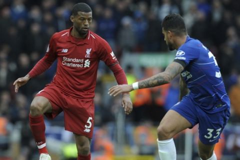 Liverpool's Georginio Wijnaldum, left, duels for the ball with Chelsea's Emerson Palmieri during the English Premier League soccer match between Liverpool and Chelsea at Anfield stadium in Liverpool, England, Sunday, April 14, 2019. (AP Photo/Rui Vieira)