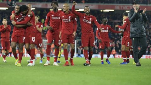 Liverpool coach Juergen Klopp, right, celebrates after Liverpool forward Divock Origi, third from left, scored his side's first goal at the end of the English Premier League soccer match between Liverpool and Everton at Anfield Stadium in Liverpool, England, Sunday, Dec. 2, 2018. (AP Photo/Jon Super)