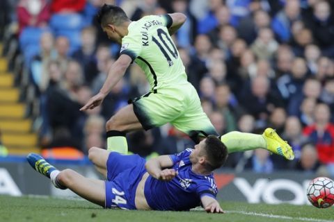 Chelsea's Gary Cahill, on the ground tackles Manchester City's Sergio Aguero during the English Premier League soccer match between Chelsea and Manchester City at Stamford Bridge stadium in London, Saturday, April 16,  2016. (AP Photo/Frank Augstein)