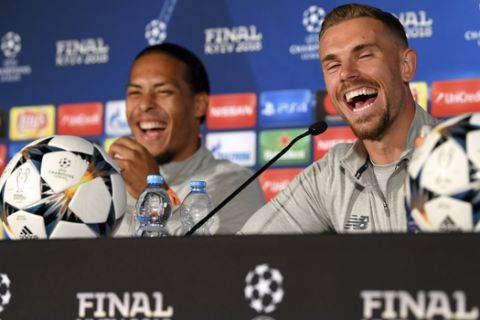 Liverpool's Virgil van Dijk, left, and Jordan Henderson laugh during a press conference at the Olympic stadium in Kiev, Ukraine, Friday, May 25, 2018 ahead of the Champions League final soccer match between Real Madrid and Liverpool on Saturday May 26. (UEFA Pool via AP)