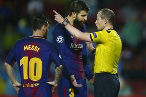 Barcelona's Gerard Pique, center, protests after getting a red card from referee William Collum, as Lionel Messi looks on during the group D Champions League soccer match between FC Barcelona and Olympiakos at the Camp Nou stadium in Barcelona, Spain, Wednesday, Oct. 18, 2017. (AP Photo/Manu Fernandez)