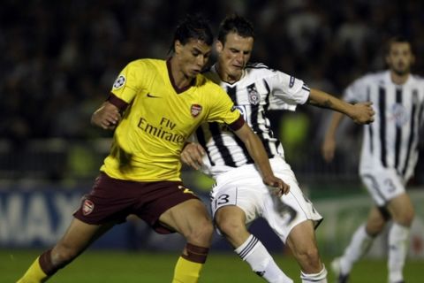 Marouane Chamakh of Arsenal, left, gets fouled by Marko Jovanovic of Partizan Belgrade during their Group H UEFA Champions League soccer match in Belgrade, Serbia, Tuesday, Sept. 28, 2010. (AP Photo/Marko Drobnjakovic)
