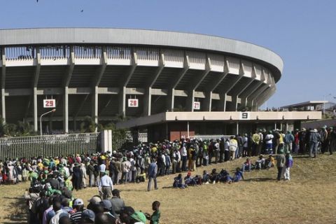 People queue to enter the stadium for the inauguration ceremony of Zimbabwean President Emmerson Mnangagwa, at the National Sports Stadium in Harare, Sunday, Aug. 26, 2018.  This is the second swearing-in of Mnangagwa in just nine months as a country once jubilant over the fall of longtime leader Robert Mugabe is now more subdued after the reemergence of harassment of the opposition. (AP Photo/Tsvangirayi Mukwazhi)