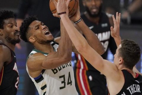 CORRECTS TO SECOND HALF, INSTEAD OF FIRST - Milwaukee Bucks' Giannis Antetokounmpo (34) is defended by Miami Heat's Duncan Robinson, right, during the second half of an NBA conference semifinal playoff basketball game Friday, Sept. 4, 2020, in Lake Buena Vista, Fla. (AP Photo/Mark J. Terrill)