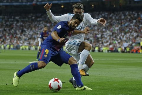 Barcelona's Luis Suarez, left, vies for the ball with Real Madrid's Mateo Kovacic during the Spanish Super Cup second leg soccer match between Real Madrid and Barcelona at the Santiago Bernabeu stadium in Madrid, Wednesday, Aug. 16, 2017. (AP Photo/Francisco Seco)