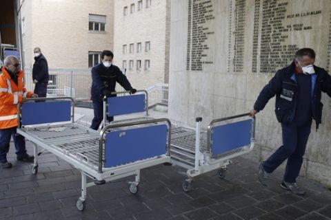 Personnel carry new beds inside the hospital of Codogno, near Lodi in Northern Italy, Friday, Feb. 21,2020. Health officials reported the country's first cases of contagion of COVID-19 in people who had not been in China. The hospital in Codogno is one of the hospitals - along with specialized Sacco Hospital in Milan - which is hosting the infected persons and the people that were in contact with them and are being isolated. (AP Photo/Luca Bruno)