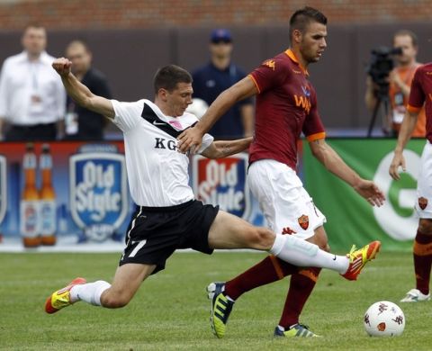 Zaglebie Lubin player Jiri Bilek (L) challenges Panagiotis Tachtsidis (R) of A.S. Roma in the first half of their team's friendly match at Wrigley Field, the home of the Chicago Cubs baseball team, in Chicago, Illinois, July 22, 2012. REUTERS/Jeff Haynes (UNITED STATES - Tags: SPORT SOCCER)