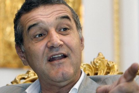 Gigi Becali, the owner of Steaua football club, and a former shepherd, gestures during an interview with the Associated Press in Bucharest, Romania, Tuesday, June 9, 2009. Romanian nationalist politician Gigi Becali has gone from a prison cell to a seat in the European Parliament in less than two months. But his seat looked uncertain Tuesday after a court upheld a travel ban on the flamboyant, religious politician, pending a criminal investigation into kidnapping charges. In an interview with the Associated Press, Becali, 50, vowed to stage "the mother of all shows" and travel to Brussels to take his seat for the nationalist Greater Romania Party whatever the outcome of the court ruling. (AP Photo/Vadim Ghirda)