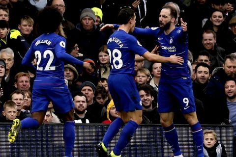 Chelsea's Gonzalo Higuain, right, celebrates with his teammates Cesar Azpilicueta, center and Willian, after scoring his side's opening goal, during the English Premier League soccer match between Fulham and Chelsea at Craven Cottage stadium in London, England, Sunday, March 3, 2019. (AP Photo/Tim Ireland)
