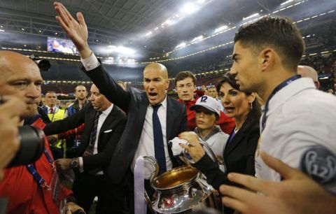 Real Madrid's head coach Zinedine Zidane celebrates with the trophy at the end of the Champions League soccer final between Juventus and Real Madrid at the Millennium Stadium in Cardiff, Wales, Saturday, June 3, 2017. Real won the match 4-1. (AP Photo/Frank Augstein)