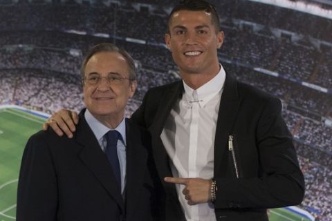 Real Madrid's Cristiano Ronaldo, right, poses with the club's President Florentino Perez after signing a new contract at the Santiago Bernabeu stadium in Madrid, Spain, Monday, Nov. 7, 2016. Real Madrid have extend Ronaldo's contract until June 2021, when the three-time world player of the year will be 36. Financial details were not released, although the star forward is expected to remain the team's top-paid player. (AP Photo/Paul White)