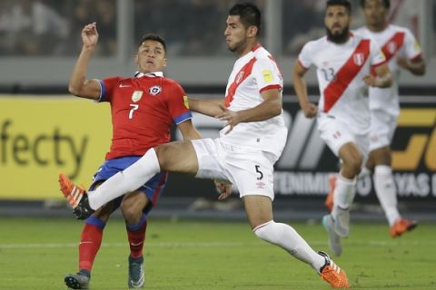 Chile's Alexis Sanchez, left, fights for the ball with Peru's Carlos Zambrano during a 2018 Russia World Cup qualifying soccer match in Lima, Peru, Tuesday, Oct. 13, 2015. (AP Photo/Martin Mejia)