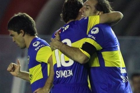 **  CORRECTS FIRST NAME OF BOCA JUNIORS' PLAYER MATIAS CARUZZO  **  Boca Juniors' Rolando Schiavi, right, celebrates with teammate Leandro Somoza, center, after scoring during an Argentine soccer league match against Independiente in Buenos Aires, Argentina, Sunday, Sept. 4, 2011. At left, Boca Juniors' Matias Caruzzo. (AP Photo/Victor R. Caivano)