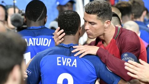 Portugal's Cristiano Ronaldo, right, embraces France's Patrice Evra at the end of  the Euro 2016 final soccer match between Portugal and France at the Stade de France in Saint-Denis, north of Paris, Sunday, July 10, 2016. Portugal won 1-0. (AP Photo/Martin Meissner)