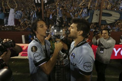 Brazil's Gremio soccer team players kiss their trophy after winning the Copa Libertadores championship following a game with Argentina's Lanus in Buenos Aires, Argentina, Wednesday, Nov. 29, 2017. (AP Photo/Esteban Felix)