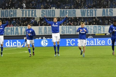 Schalke's Leon Goretzka, center, exercises in front of protest banners prior the German Bundesliga soccer match between FC Schalke 04 and Hannover 96 in Gelsenkirchen, Germany, Sunday, Jan. 21, 2018. The club announced that it's key player Goretzka will leave the club after the season to play for Bayern Munich. (AP Photo/Martin Meissner)