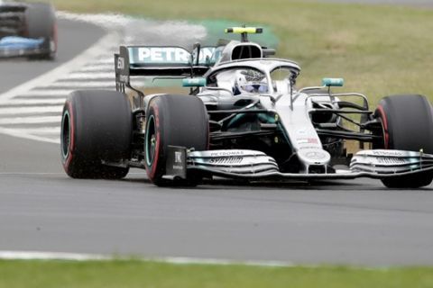 Mercedes driver Valtteri Bottas of Finland steers his car followed by Williams driver Robert Kubica of Poland during the third free practice at the Silverstone racetrack, in Silverstone, England, Saturday, July 13, 2019. The British Formula One Grand Prix will be held on Sunday. (AP Photo/Luca Bruno)