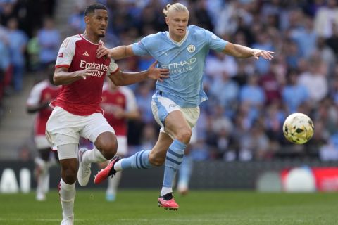 Arsenal's William Saliba, left, challenges for the ball with Manchester City's Erling Haaland during the English FA Community Shield final soccer match between Arsenal and Manchester City at Wembley Stadium in London, Sunday, Aug. 6, 2023. (AP Photo/Kirsty Wigglesworth)