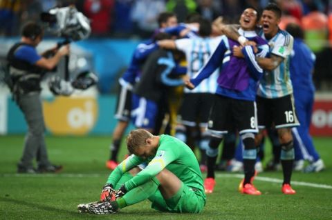 SAO PAULO, BRAZIL - JULY 09:  Jasper Cillessen of the Netherlands reacts after being defeated by Argentina in a penalty shootout as Enzo Perez and Marcos Rojo of Argentina celebrate during the 2014 FIFA World Cup Brazil Semi Final match between the Netherlands and Argentina at Arena de Sao Paulo on July 9, 2014 in Sao Paulo, Brazil.  (Photo by Clive Rose/Getty Images)