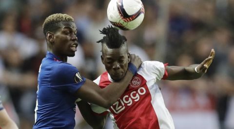 Manchester's Paul Pogba, left, holds Ajax's Bertrand Traore during the soccer Europa League final between Ajax Amsterdam and Manchester United at the Friends Arena in Stockholm, Sweden, Wednesday, May 24, 2017. (AP Photo/Michael Sohn)