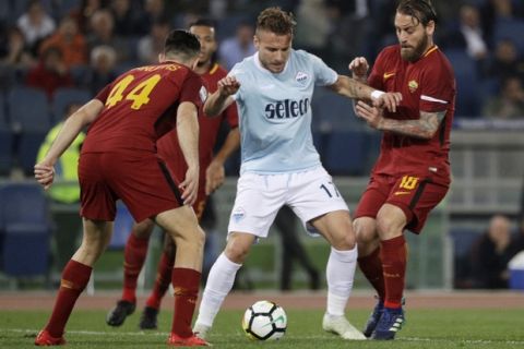 Lazio's Ciro Immobile is caught in between Roma's Kostas Manolas and Roma's Daniele De Rossi, right, during an Italian Serie A soccer match between AS Roma and Lazio, at the Olympic stadium in Rome, Sunday, April 15, 2018. (AP Photo/Gregorio Borgia)