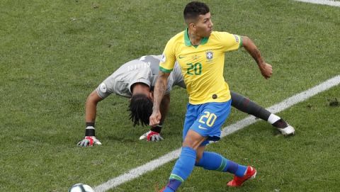 Brazil's Roberto Firmino, right, dribbles past Peru's goalkeeper Pedro Gallese to score his side's second goal during a Copa America Group A soccer match at the Arena Corinthians in Sao Paulo, Brazil, Saturday, June 22, 2019. (AP Photo/Nelson Antoine)