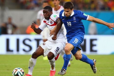 RECIFE, BRAZIL - JUNE 29:  Joel Campbell of Costa Rica and Sokratis Papastathopoulos of Greece compete for the ball during the 2014 FIFA World Cup Brazil Round of 16 match between Costa Rica and Greece at Arena Pernambuco on June 29, 2014 in Recife, Brazil.  (Photo by Paul Gilham/Getty Images)