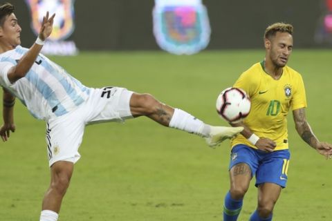 Argentina's Paulo Dybala, left, controls the ball against Brazil's Neymar during a friendly soccer match between Brazil and Argentina at King Abdullah stadium in Jiddah, Saudi Arabia, Tuesday, Oct. 16, 2018. (AP Photo)