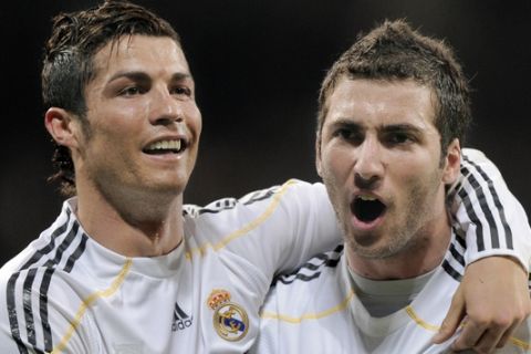 Real Madrid's Gonzalo Higuain from Argentina, right, celebrates with team mate Cristiano Ronaldo from Portugal after scoring a goal against Sporting de Gijon during his La Liga soccer match at the Santiago Bernabeu stadium in Madrid, Saturday, March 20, 2010.(AP Photo/Daniel Ochoa de Olza)