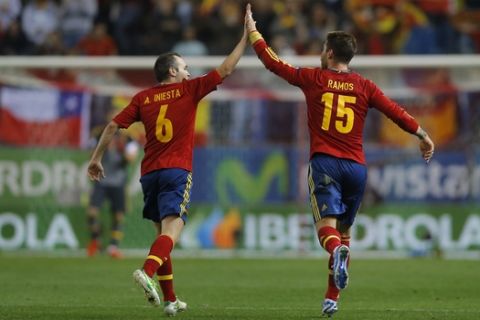Spain's Sergio Ramos celebrates with team mate Andres Iniesta, left, after scoring a goal against France, during a World Cup Group I qualifying soccer match at Vicente Calderon Stadium in Madrid, Tuesday Oct. 16, 2012. (AP Photo/Daniel Ochoa de Olza)