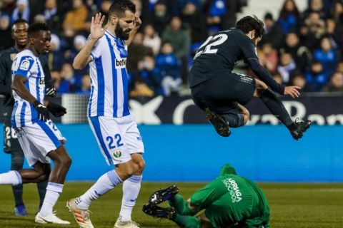 Real Madrid's Isco Alarcon, right, jumps next to Leganes' goalkeeper Cuellar during a Spanish Copa del Rey soccer match between Leganes and Real Madrid at the Butarque stadium in Leganes, Spain, Wednesday, Jan. 16, 2019. (AP Photo/Valentina Angela)