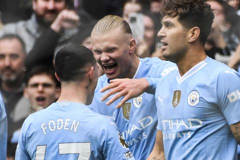 Manchester City's Erling Haaland celebrates with his teammate Phil Foden after scoring his side's first goal during the English Premier League soccer match between Manchester City and and Everton, at the Etihad stadium in Manchester, England, Saturday, February 10, 2024. (AP Photo/Rui Viera)
