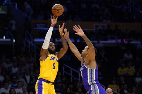 Los Angeles Lakers forward LeBron James, left, shoots as Sacramento Kings forward Trey Lyles defends during the first half of a preseason NBA basketball game Monday, Oct. 3, 2022, in Los Angeles. (AP Photo/Mark J. Terrill)
