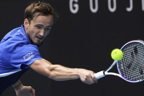 Russia's Daniil Medvedev makes a backhand return to Switzerland's Stan Wawrinka during their fourth round singles match at the Australian Open tennis championship in Melbourne, Australia, Monday, Jan. 27, 2020. (AP Photo/Andy Brownbill)