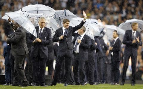 Former Tottenham players use umbrellas to keep off the rain during a final ceremony on the pitch after the last match played at the ground, the English Premier League soccer match between Tottenham Hotspur and Manchester United at White Hart Lane stadium in London, Sunday, May 14, 2017. It was the last Spurs match at the old stadium, a new stadium is being built on the site. (AP Photo/Frank Augstein)