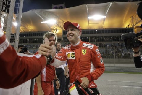 Ferrari driver Sebastian Vettel of Germany celebrates with his teammates after getting the pole position in the qualifying session for the Bahrain Formula One Grand Prix, at the Formula One Bahrain International Circuit in Sakhir, Bahrain, Saturday, April 7, 2018. The Bahrain Formula One Grand Prix will take place here on Sunday. (AP Photo/Luca Bruno)