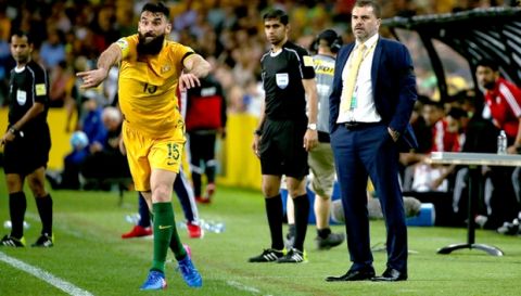 Australia's Mile Jedinak, left, throws the ball in as his coach, Ange Postecoglou, right, watches during their World Cup qualifying soccer match against United Arab Emirates in Sydney, Tuesday, March 28, 2017. (AP Photo/Rick Rycroft)