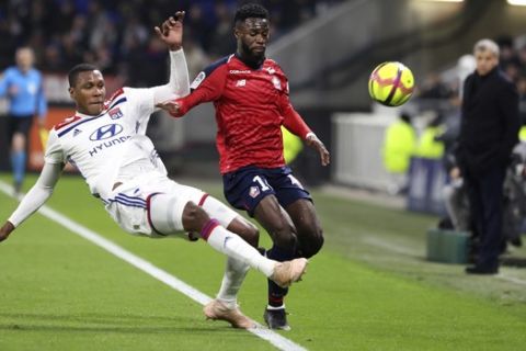 Lille's Jonathan Bamba, right, is tackled by Lyon's Marcelo Guedes Filho, left, during their French League One soccer match in Decines, near Lyon, central France, Sunday, May 5, 2019. (AP Photo/Laurent Cipriani)