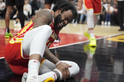 Atlanta Hawks forward Saddiq Bey (41) holds his leg after he was injured during the first half of an NBA basketball game against the New Orleans PelicansSunday, March 10, 2024, in Atlanta. (AP Photo/John Bazemore)