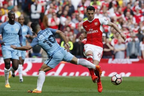 Manchester City's Sergio Aguero vies for the ball with Arsenal's Granit Xhaka during the English FA Cup semifinal soccer match between Arsenal and Manchester City at Wembley stadium in London, Sunday, April 23, 2017. (AP Photo/Kirsty Wigglesworth)